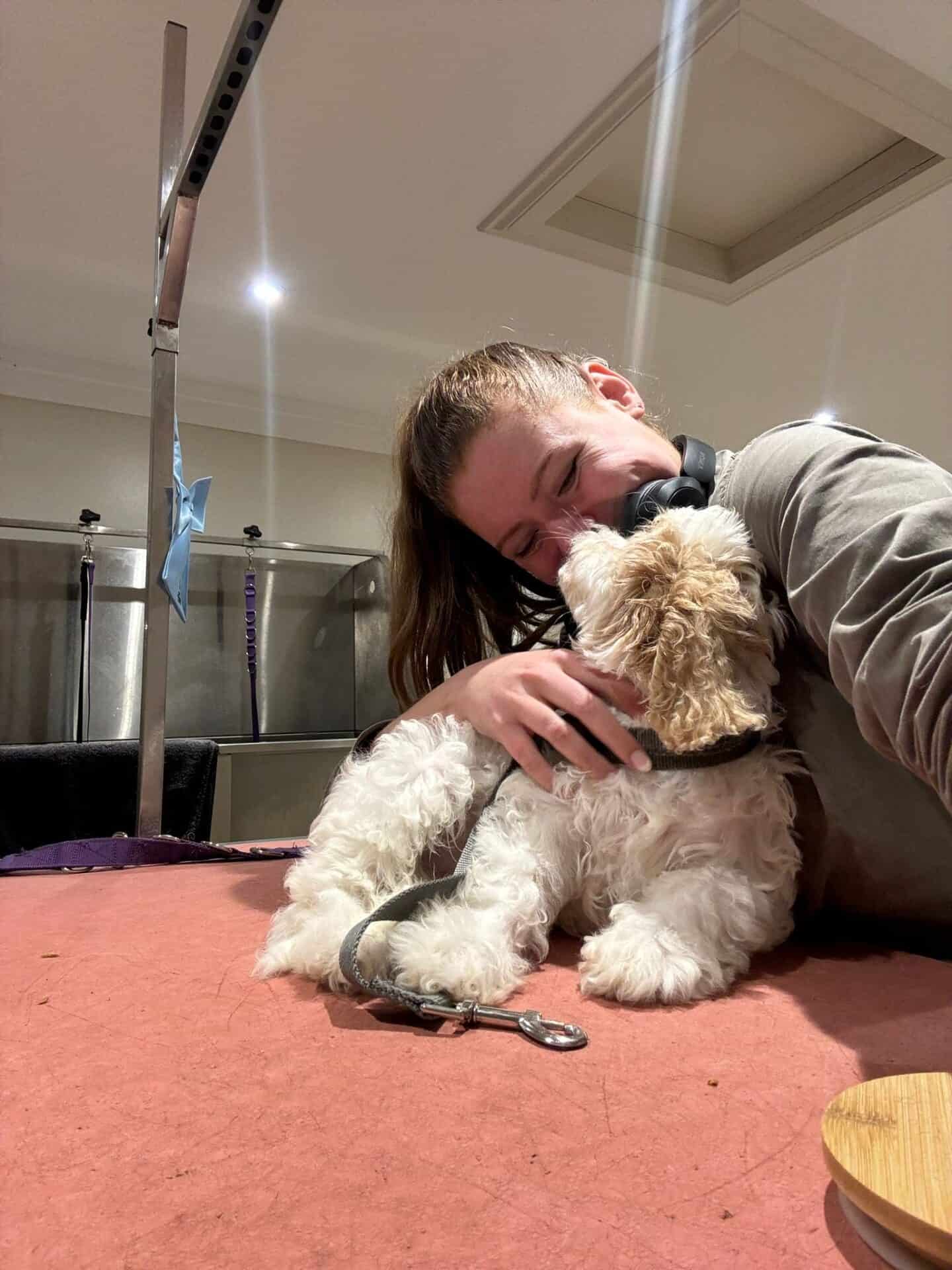 Picture of Fiona cuddling a freshly groomed dog